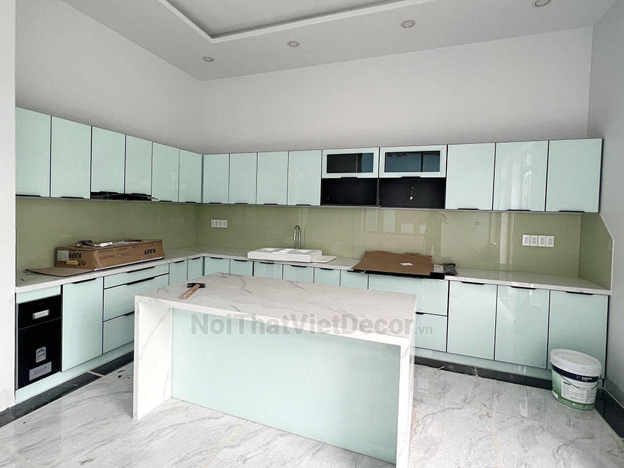 Tủ bếp hiện đại chữ L có đảo, khung inox 304 sơn tĩnh điện, cánh kính sơn màu viền nhôm, mặt bếp đá nhân tạo marble trắng vân mây, ốp tường kính cường lực 8mm - Hoàn thiện