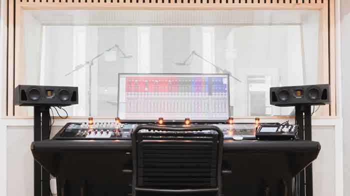 ADAM Audio A44H Dual 4-inch hình đang được chụp miêu tả sản phẩm loa đang được trưng trên kệ chân loa và đang kết nối với PC và đang chạy phần mềm để nghe và làm nhạc 