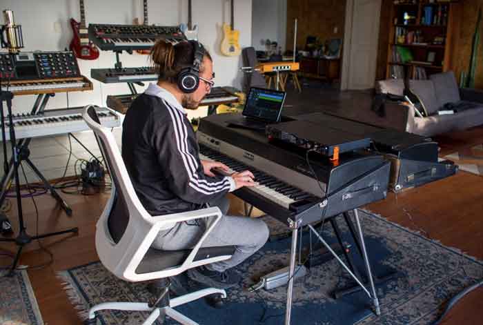 Arturia AudioFuse 16Rig USB Audio hình ảnh đang được trong phòng có một người đàn ông đang chơi đàn và kết nối với sản phẩm đặt trên cây đàn