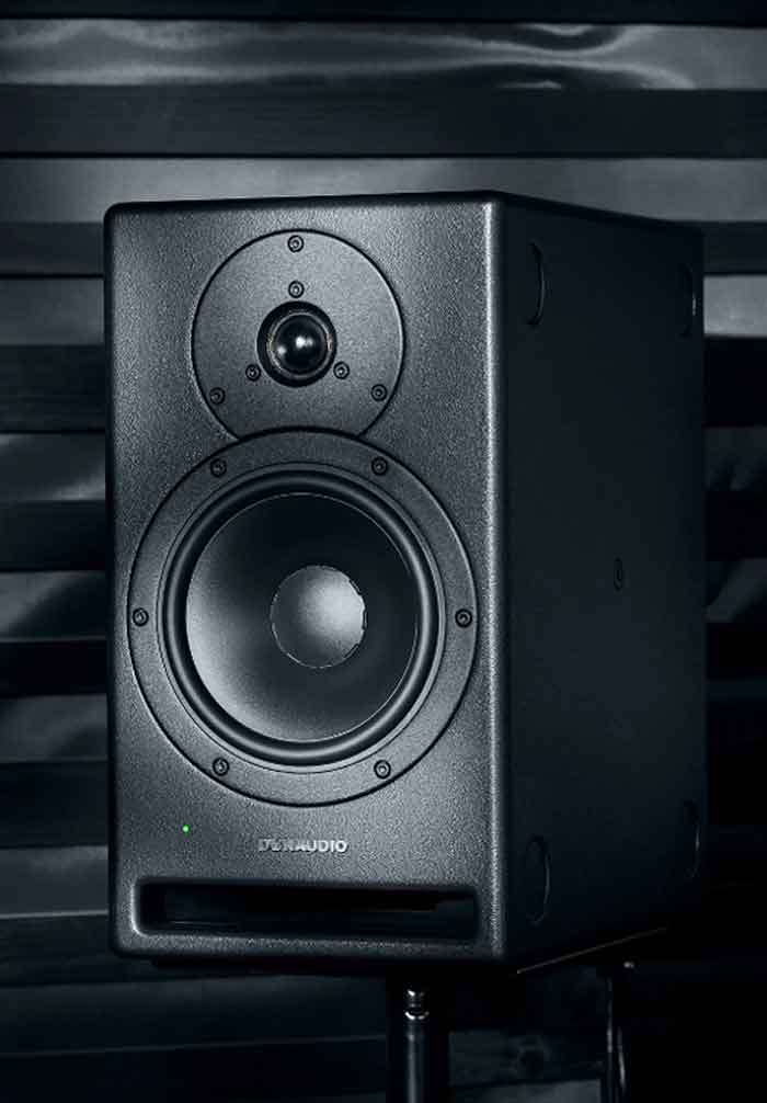 Dynaudio Core 7 7 inch Studio Monitor hình đang được chụp chi tiết chính diện miêu tả sản phẩm đang được đặt trên bàn và nền sau có màu tối 