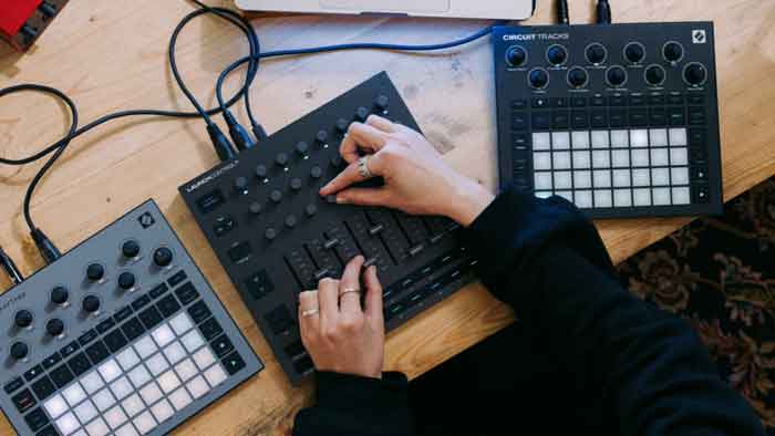 Novation Launch Control XL Mk3 hình đang mô tả chi tiết sản phẩm đang được chụp miêu tả từ góc trên xuống và đang đươc kết nối với 2 thiết bị khác và đang đặt trên bàn 