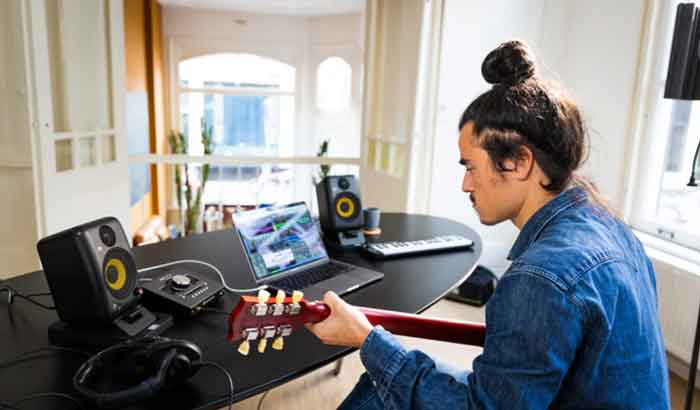 Loa Kiểm Âm KRK Classic 7 hình đang miêu tả người đàn ông trong hình đang set úp loa kết nối với soundcard và laptop để chơi đàn 