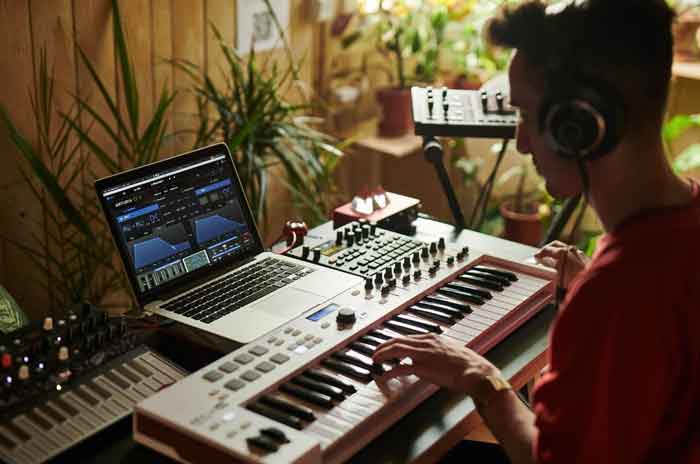 Phần mềm Synth Arturia CZ V hình đang miêu tả người đàn ông trong hình đang chơi đàn và kết nối với laptop có phầm mềm