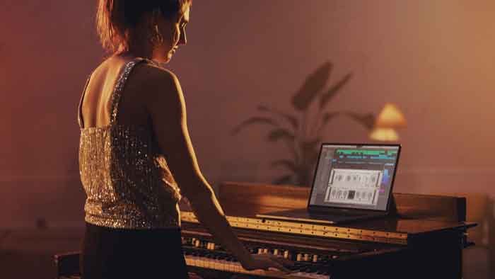 Plug-in Arturia Rotary CLS-222 hình đang mô tả một người phụ nữ đang chơi đàn và có laptop đang đặt trên bàn và hiểu thị phầm mền