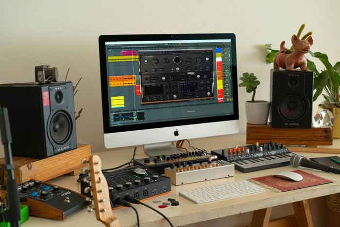 Plug-in Arturia Intensity Reverb hình đang mô tả một góc trong phòng nhiêu thiết bị đang kết nối với nhau được đặt trên bàn 