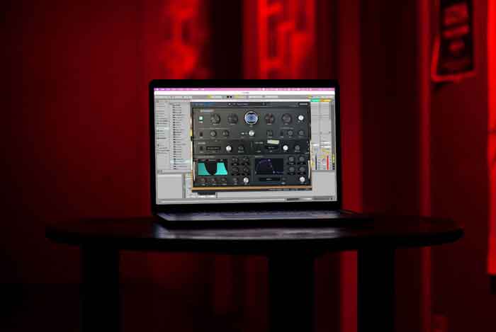 Plug-in Arturia Intensity Reverb hình đang được miêu tả laptop đang được đặt trên bàn vời màng hình đang hiển thị ứng dụng 