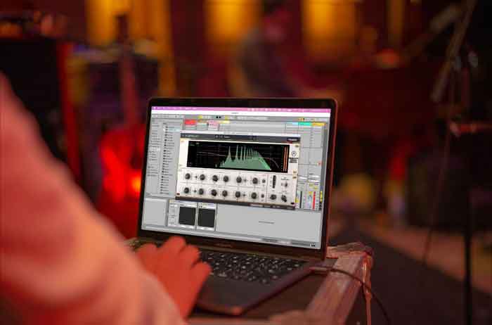 Plug-in cân bằng Arturia EQ Sitral-295 hình đang miêu tả laptop đang được đặt trên bàn và đang mở phầm mềm 