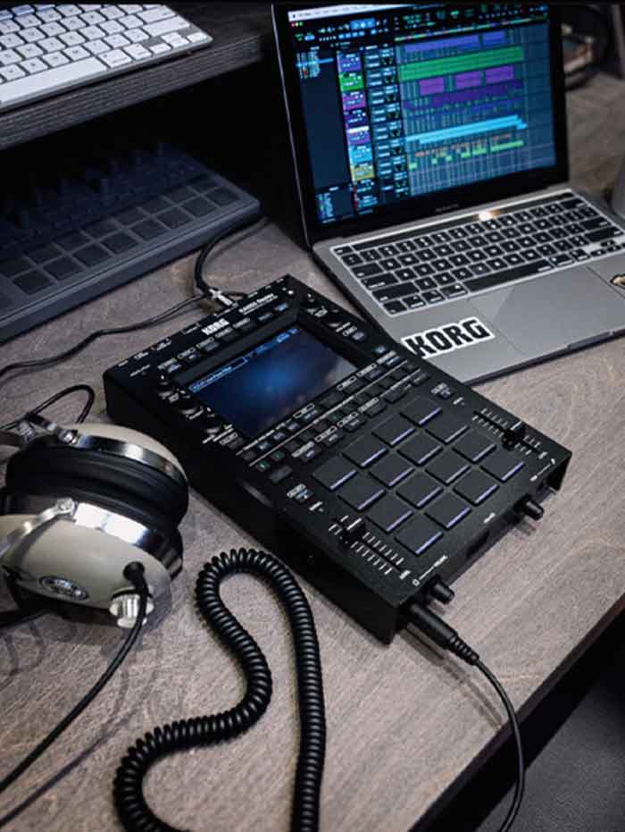 sampler Bộ xử lý âm thanh Korg KAOSS Replay sampler đang được đặt trên bàn và kết nối với laptop và tay nghe 