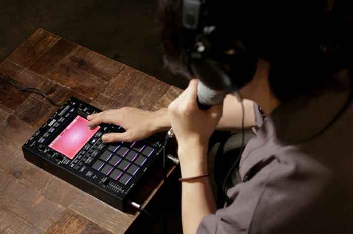 sampler Bộ xử lý âm thanh Korg KAOSS Replay sampler đang đặt trên bàn và kết nối với micro và người trong hình sử dụng