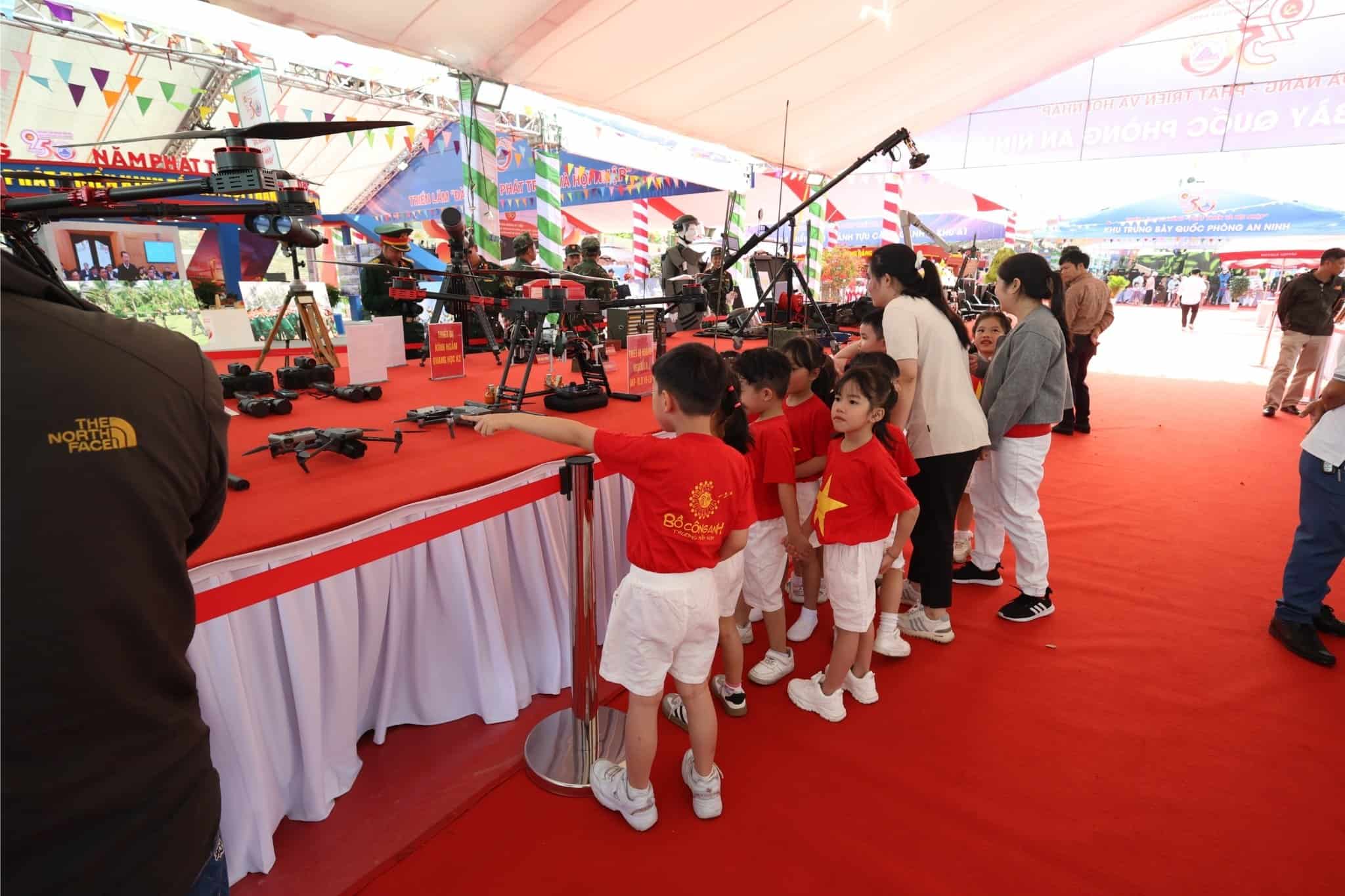 Các em nhỏ tham quan gian hàng trưng bày thiết bị quân sự tại triển lãm Đà Nẵng 2025