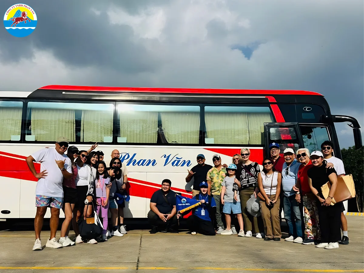 Đoàn du khách chụp ảnh kỷ niệm trước xe 29 chỗ Phan Văn Travel