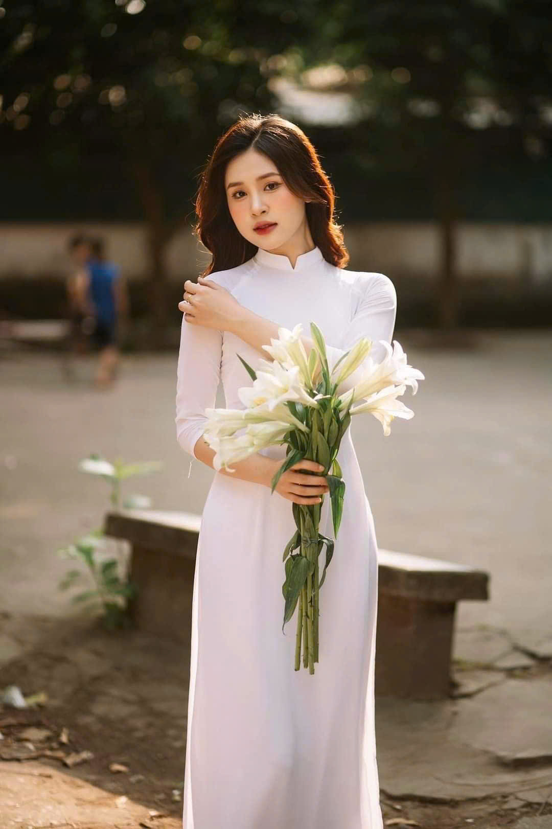 Hình ảnh nữ sinh mặc áo dài trắng bên đóa hoa ly