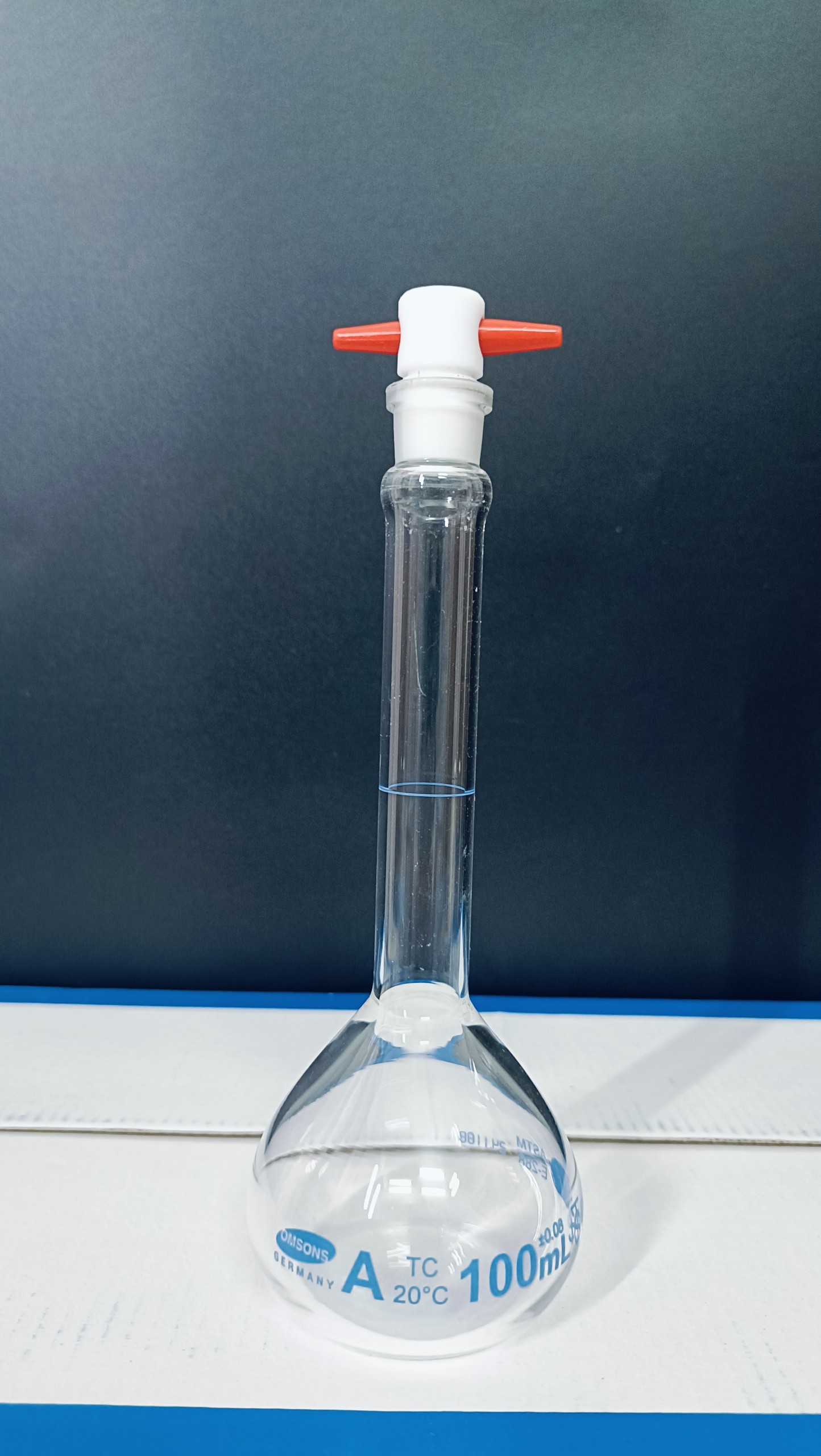 Bình định mức trắng 100ml, khóa nhựa, Class A, Hãng OMSONS GERMANY