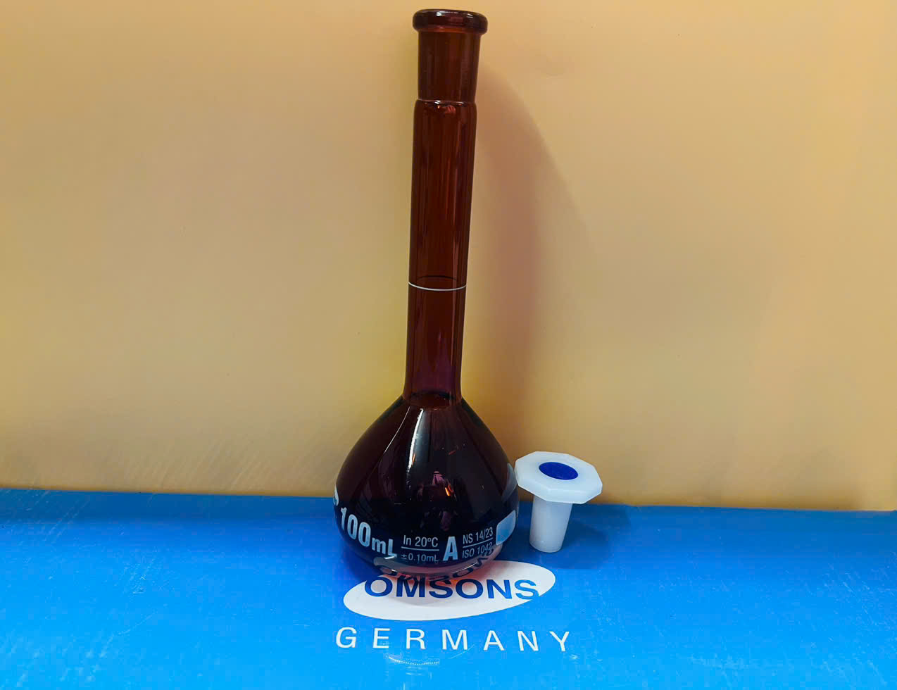 Bình định mức nâu 100ml, Class A, nút nhựa, Hãng OMSONS GERMANY