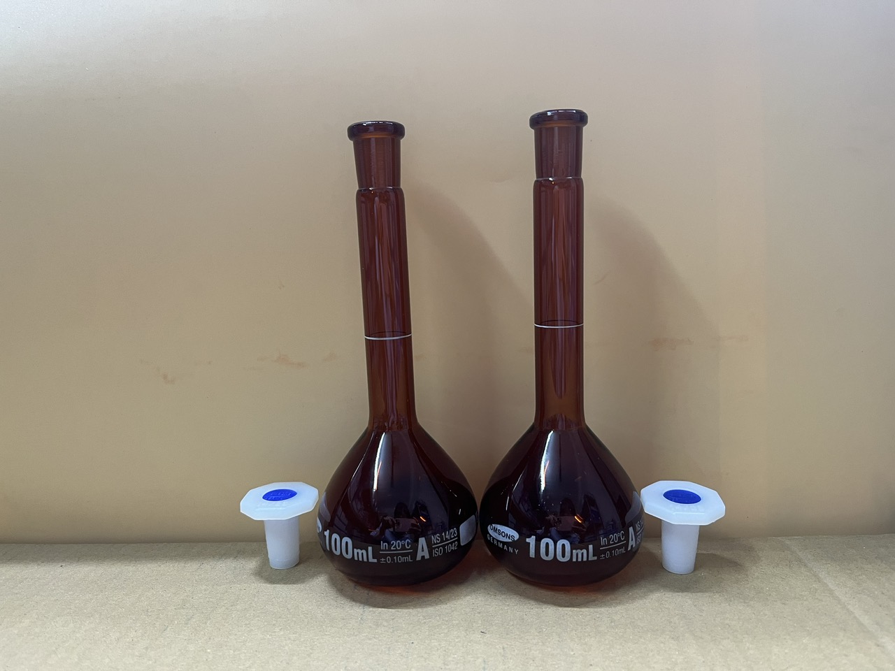 Bình định mức nâu 100ml, Class A, nút nhựa, Hãng OMSONS GERMANY