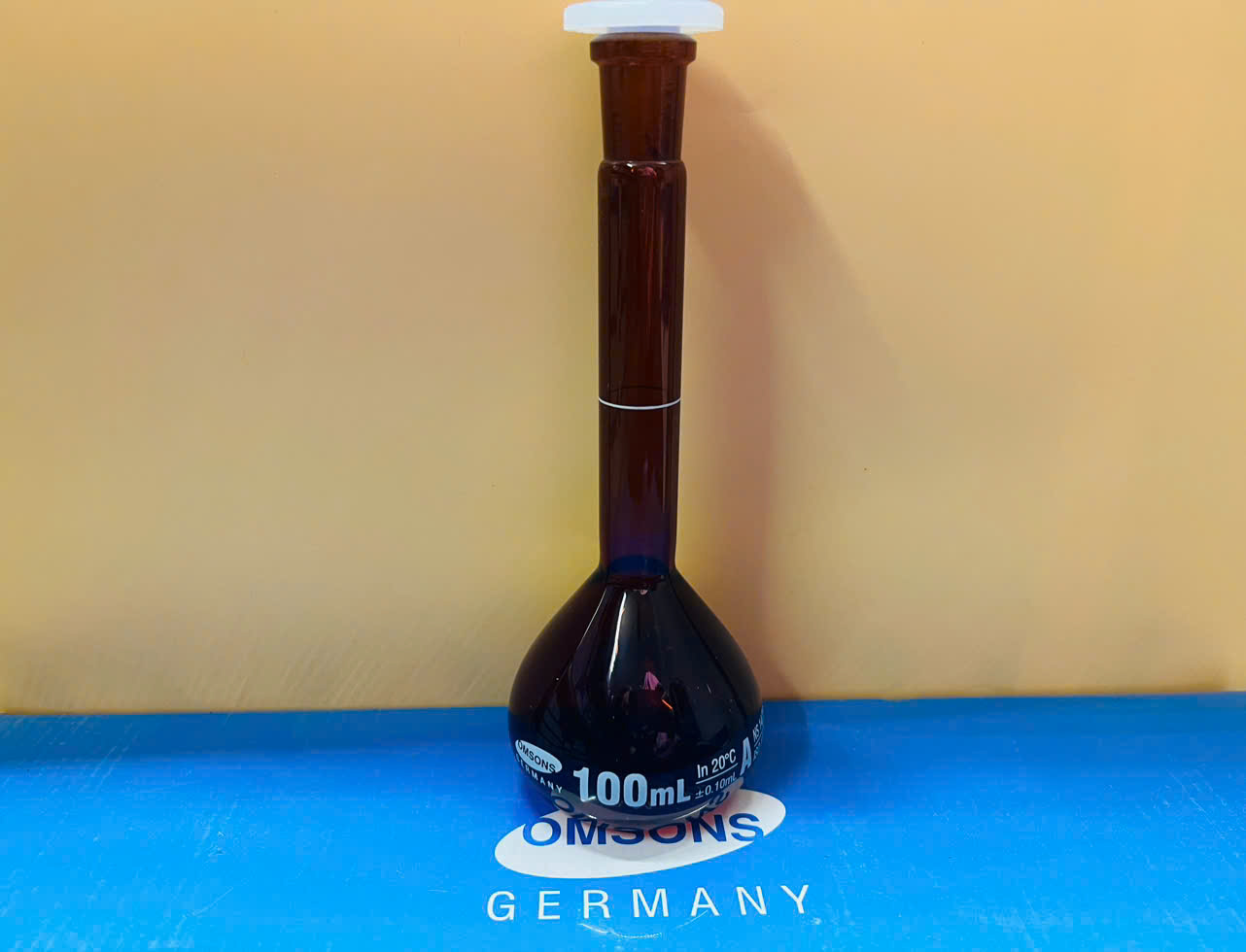 Bình định mức nâu 100ml, Class A, nút nhựa, Hãng OMSONS GERMANY