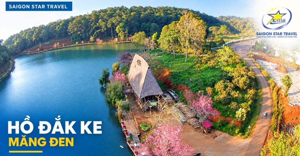 Hồ Đắk Ke Măng Đen nhìn từ trên cao với nhà mái dốc và hàng cây nở hoa bên hồ