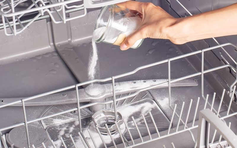 Rắc một cốc baking soda vào máy rửa bát để khử mùi và làm sạch Rắc một cốc baking soda vào máy rửa bát để khử mùi và làm sạch