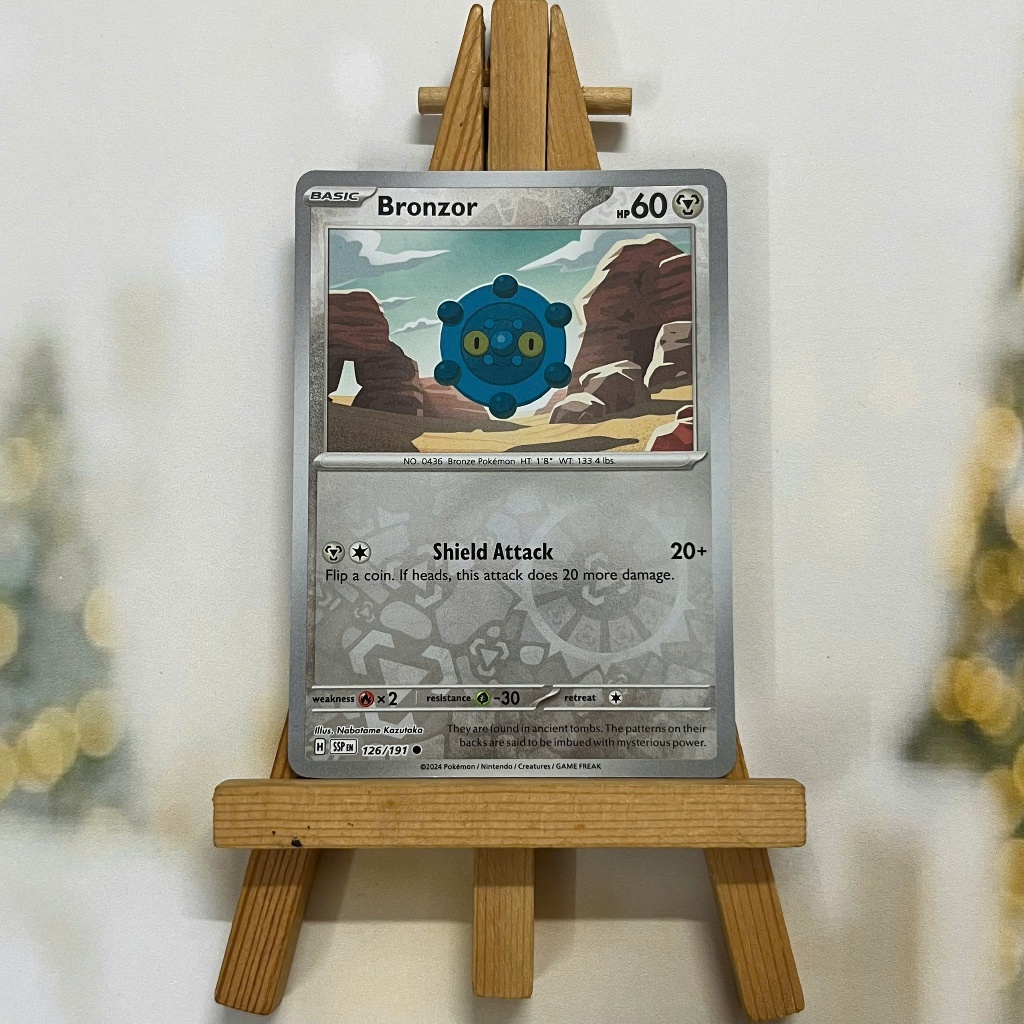 Thẻ hình Pokemon Bronzor 126/191 - Lá bài lẻ Surging Sparks Common Reverse Holo tiếng Anh chính hãng