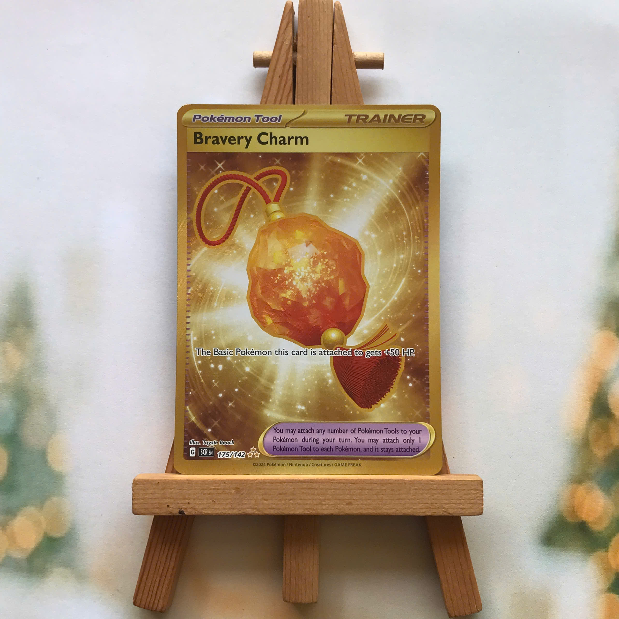 Thẻ hình Pokemon Bravery Charm 175/142 - Lá bài lẻ Scarlet & Violet: Stellar Crown Gold Secret Rare tiếng Anh