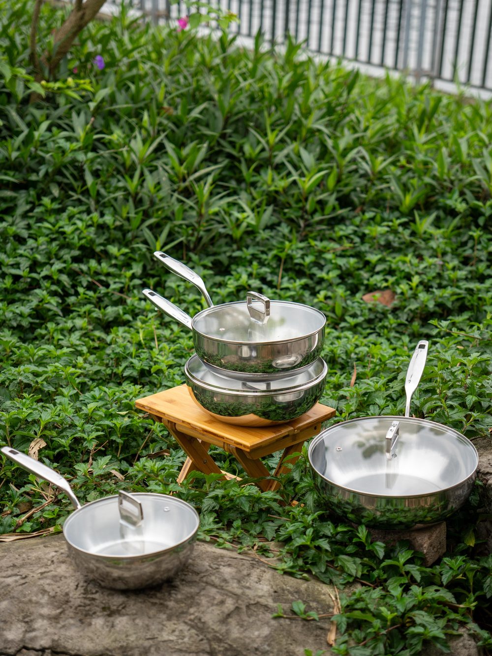 Chảo inox 316 sâu lòng Haatz Yeon có vung kính đặt trên ghế gỗ giữa vườn
