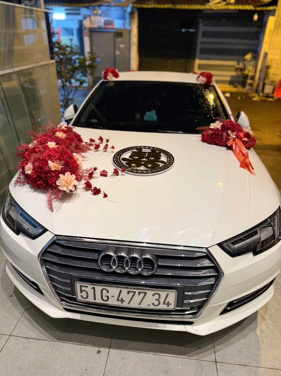 Cận cảnh xe cưới Audi A4 trắng với hoa trang trí màu đỏ