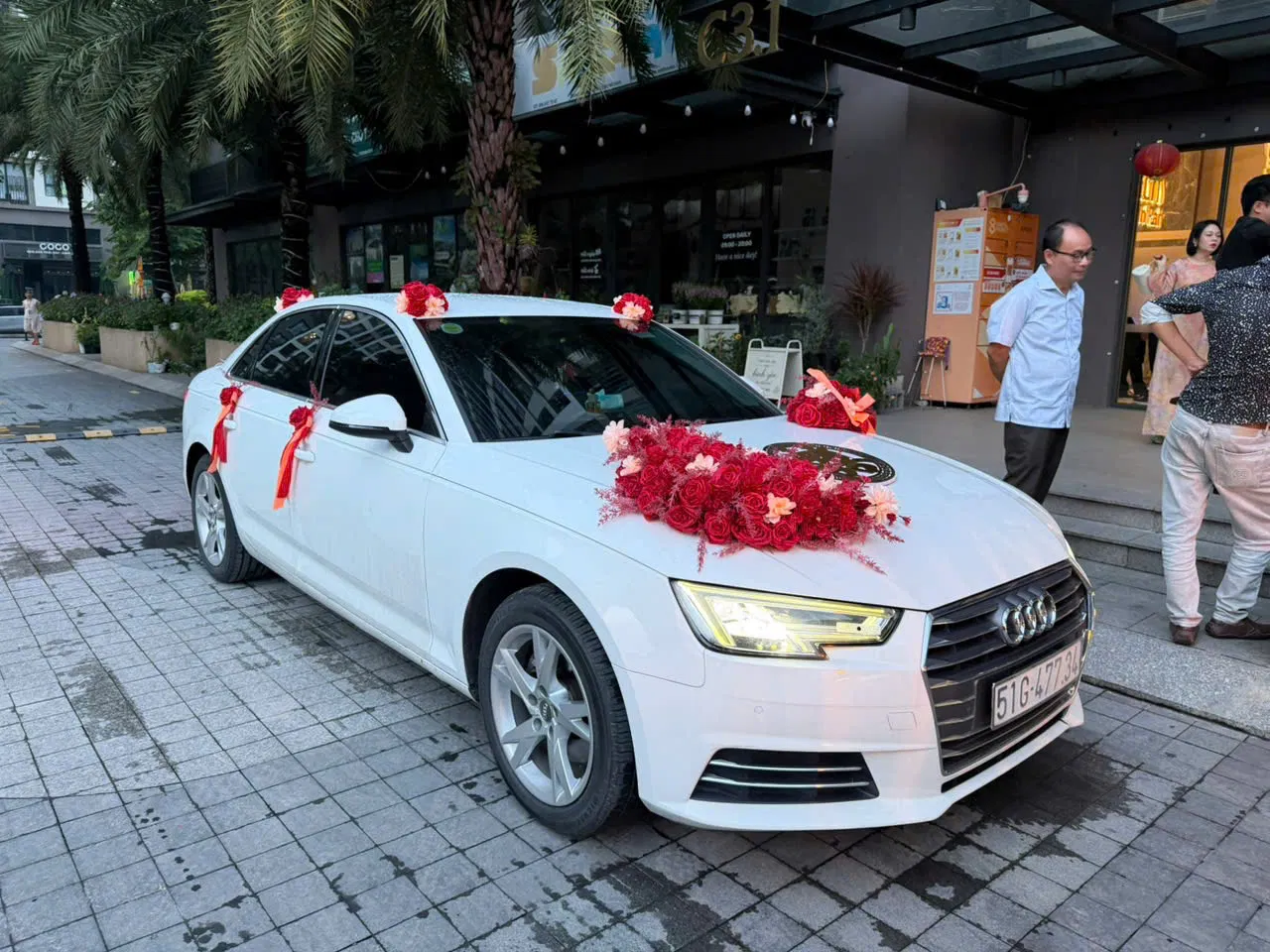 Audi A4 trang trí hoa cưới đỏ chụp góc phía trước