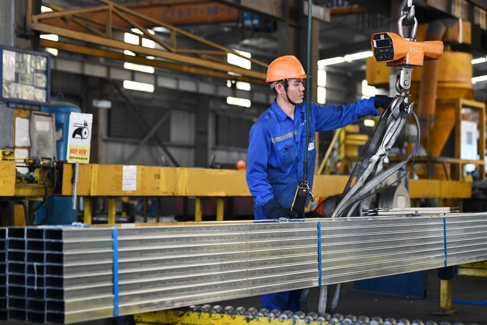 Công nhân đang kiểm tra thép xem có đạt yêu cầu chất lượng không
