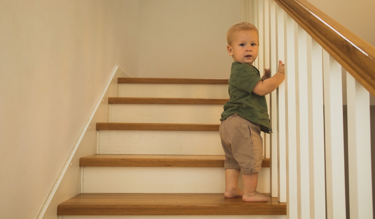 Hình ảnh bé leo cầu thang nhẹ nhàng trong giai đoạn bé tập đi để kích thích đôi chân và tránh được các bệnh về chân như là chân chữ X