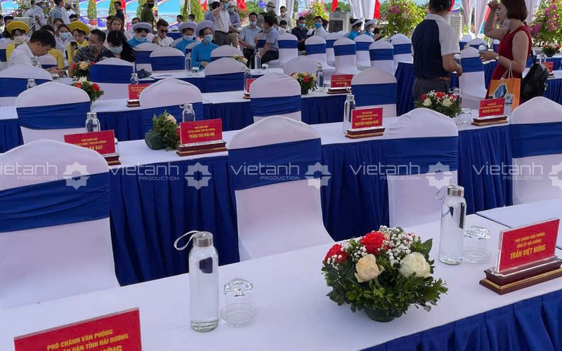 Bàn IBM phủ khăn trắng váy xanh và dải trang trí tại sự kiện