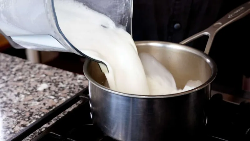 Nấu nước đã lọc cùng với sữa để hoàn thành món sữa hạt thông thơm ngon