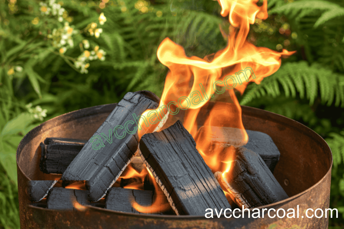 Red hot compressed briquette charcoal burning on a grill without smoke or sparks.