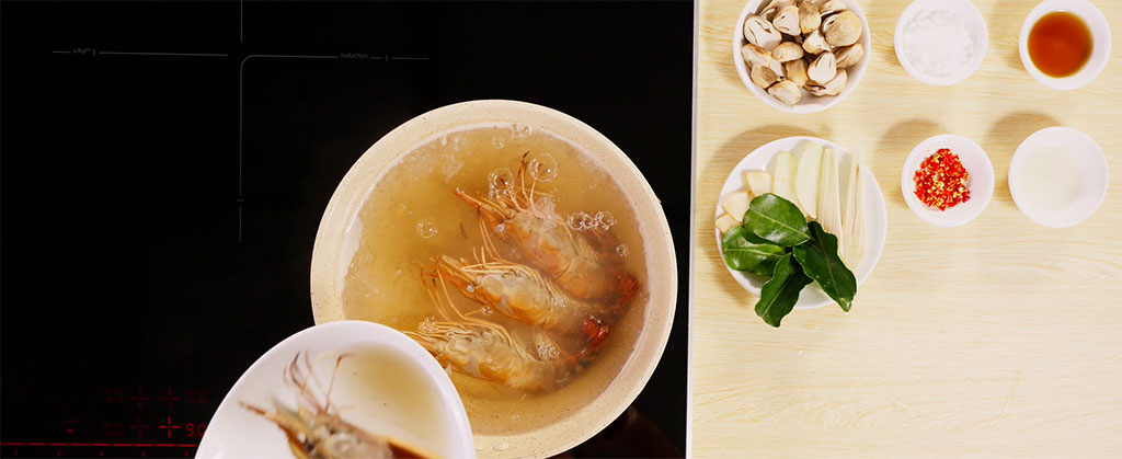 Nồi nước dùng trong veo đang sôi nhẹ trên bếp từ Bosch hiện đại