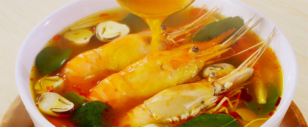 Đầu bếp múc canh chua tôm ra bát sứ trắng sang trọng