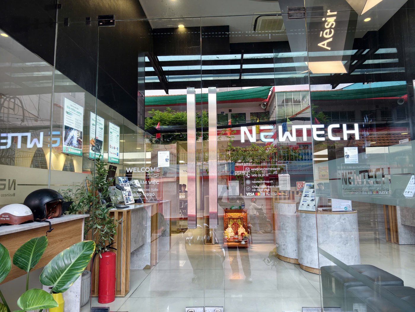 Cửa kính ra vào Showroom NewTechShop với thông tin giờ làm việc và dịch vụ minh bạch