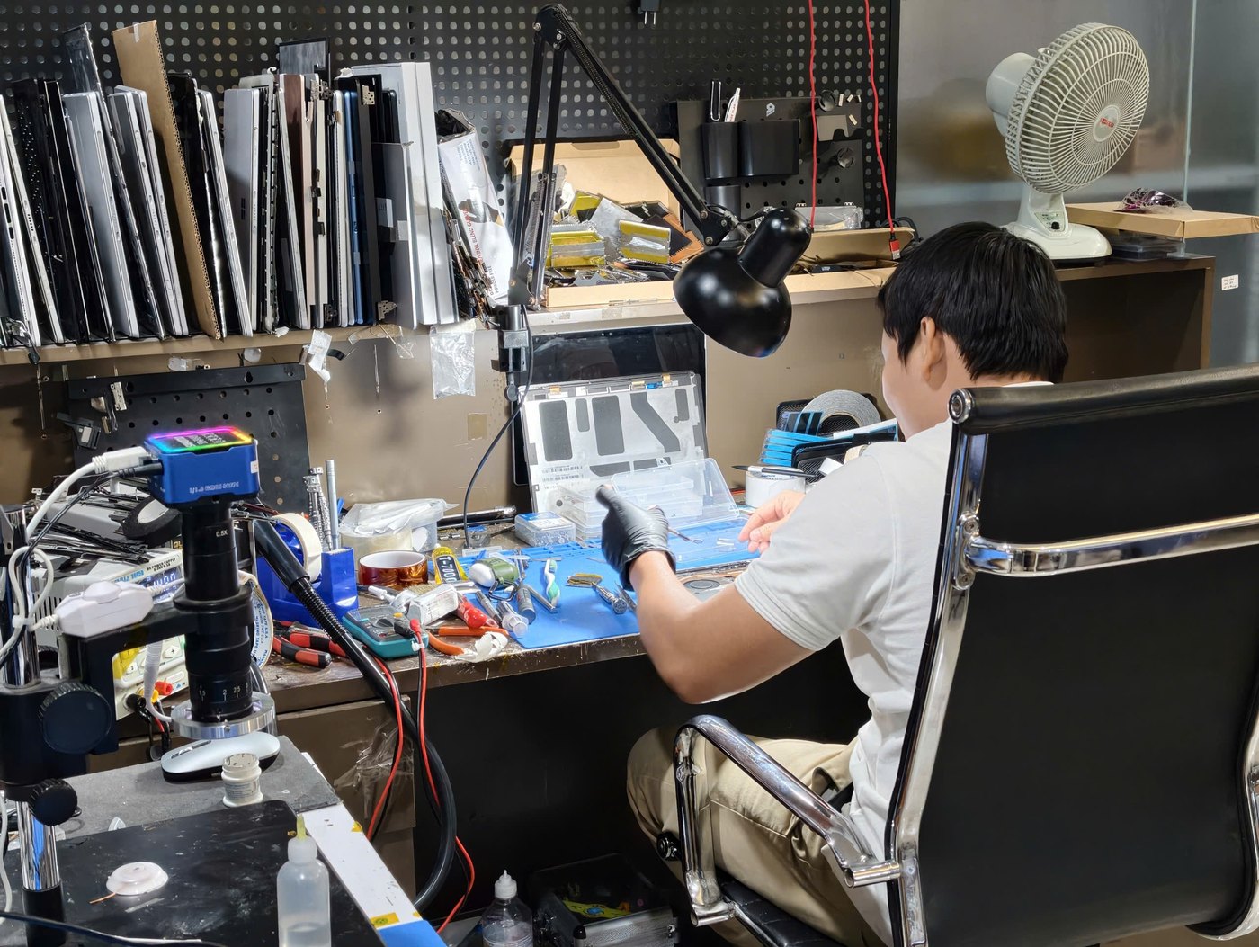 Kỹ thuật viên NewTechShop sửa chữa laptop trong phòng Lab vi mạch chuyên sâu