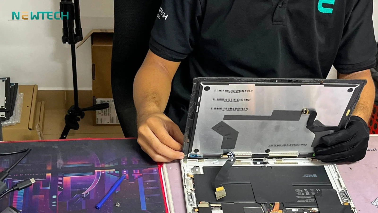 Kỹ thuật viên bóc tách màn hình Surface và thay thế cáp kết nối bàn phím zin bóc máy tại NewTechshop