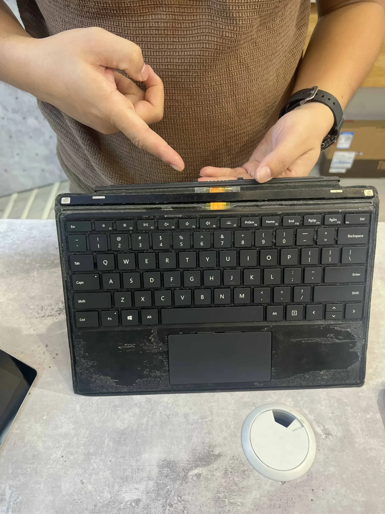 Kỹ thuật viên NewTechshop kiểm tra cổng kết nối bàn phím Surface bằng bàn phím test chuyên dụng