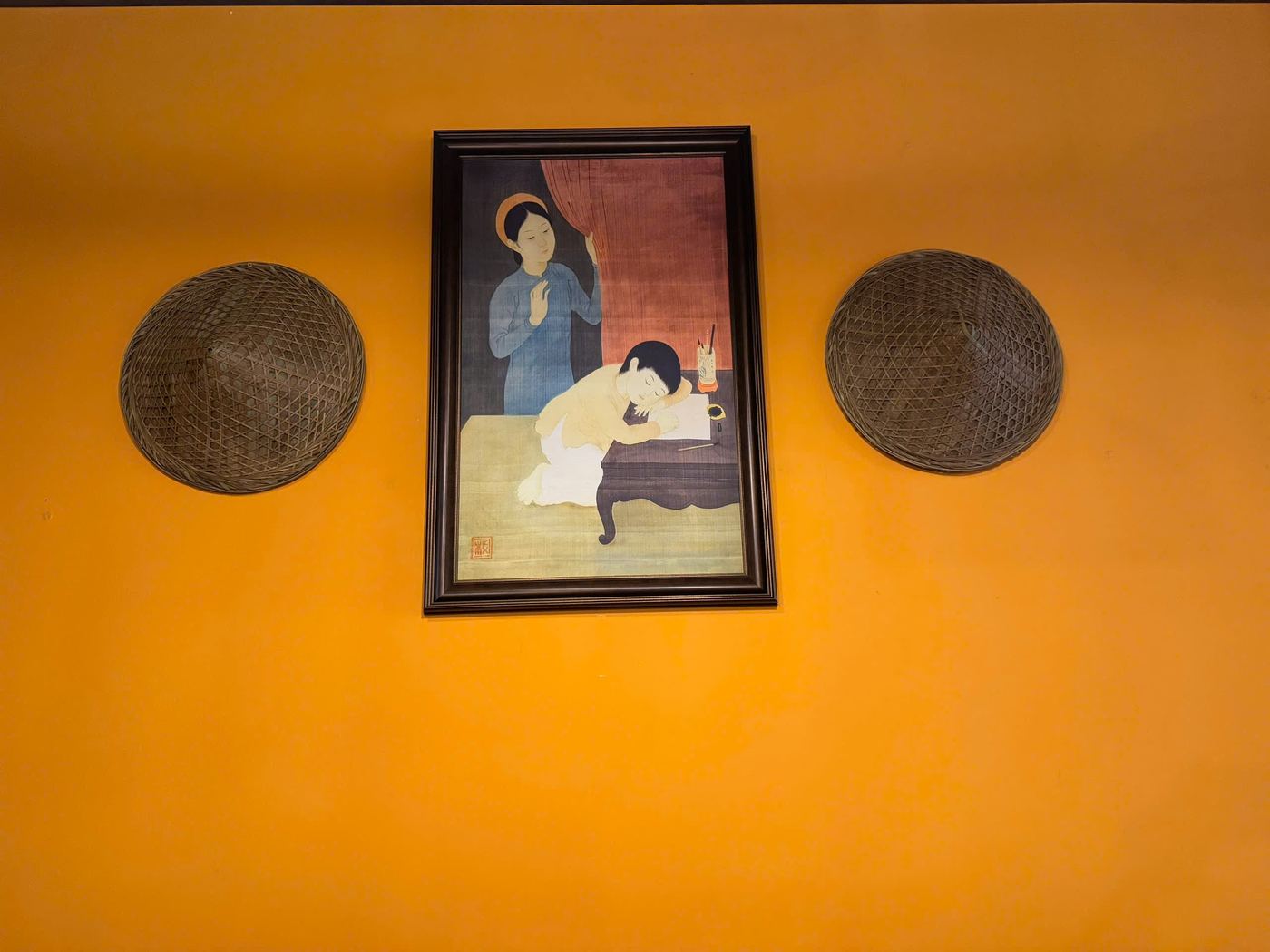 Countryside painting and conical hats decor at Quê Ta
