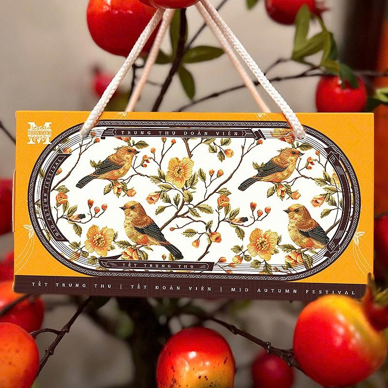 Mặt sau hộp trung thu 2 bánh Hồng Nguyệt Vàng là những cánh chim và hoa lá, có quai xách