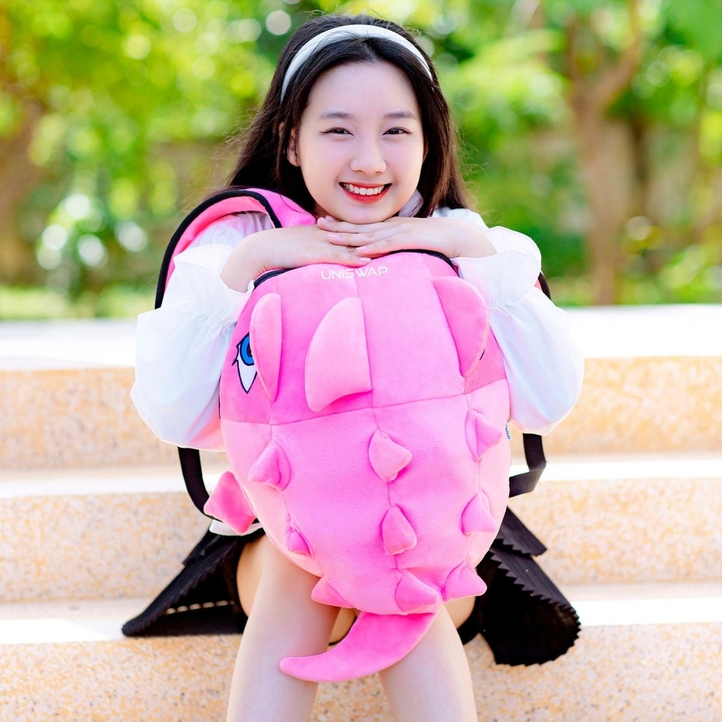 ảnh người mẫu đeo balo khủng long uniswap màu hồng dễ thuong
