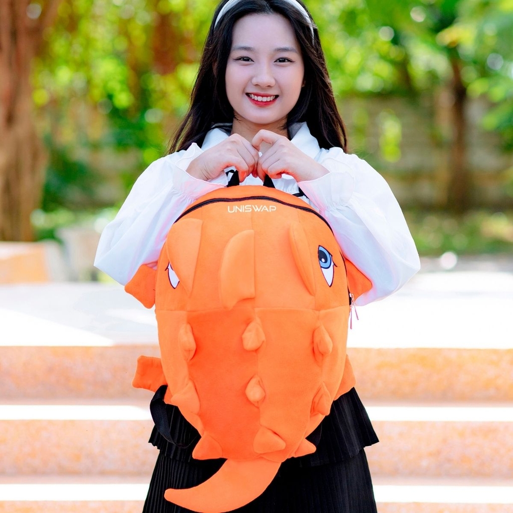 ảnh người mẫu đeo balo khủng long uniswap màu cam nổi bật