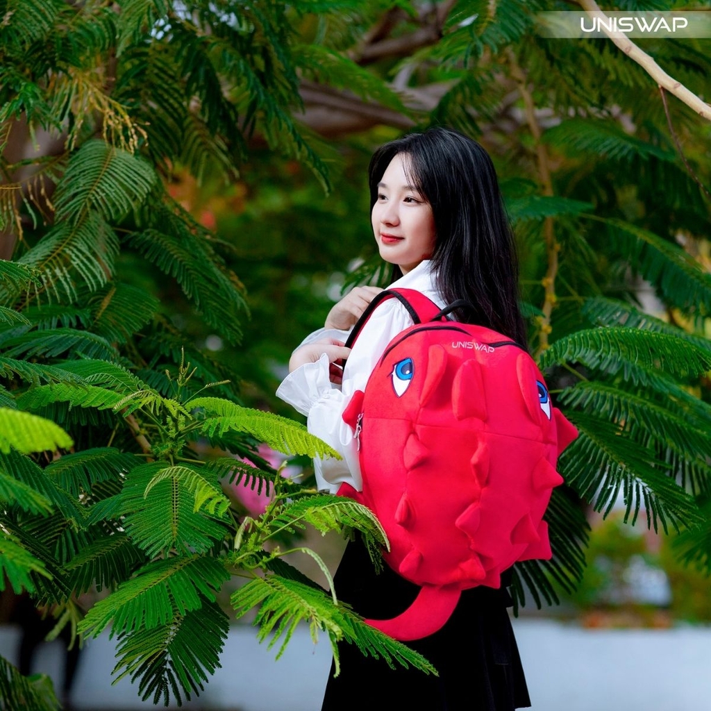 ảnh người mẫu đeo balo khủng long uniswap màu đỏ