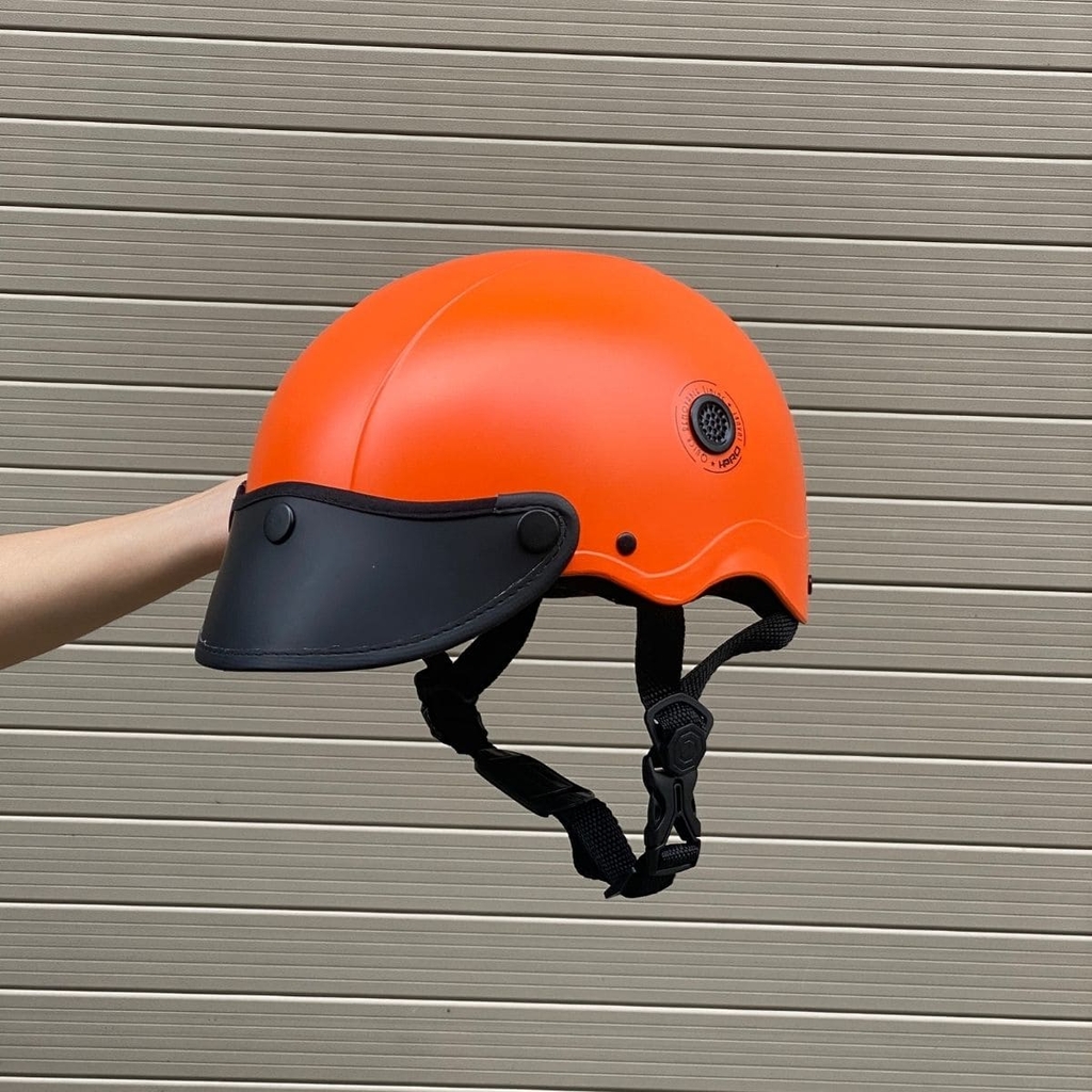 Góc nghiêng trái làm nổi bật tông cam nhám chống bám bẩn, kết hợp lưỡi trai đen cá tính phù hợp đi phố hằng ngày.