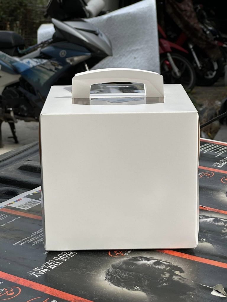 hộp bánh kem quai xách trắng cửa sổ