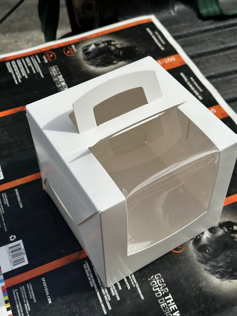 hộp bánh kem quai xách trắng trơn cửa sổ