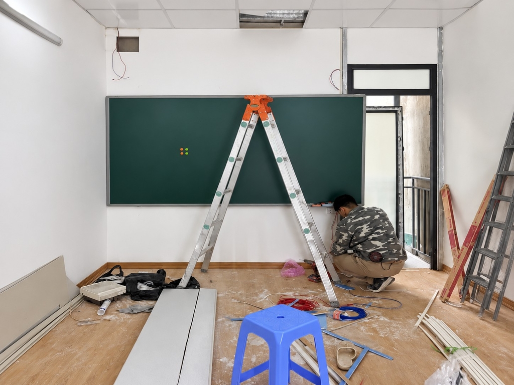 Kỹ thuật viên thi công bảng viết xanh tại phòng học