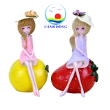 Tượng cô gái dễ thương ngồi trên trái cây mùa hè