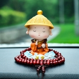 Tượng chú tiểu gật đầu đội nón áo cam cưỡi mây