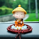 Tượng chú tiểu gật đầu đội nón áo cam cưỡi mây